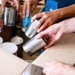 Volunteers Packing humanitarian aid in donation box. Group of unrecognizable people working in charitable foundation helping in crises and homeless.Donation and charity concept